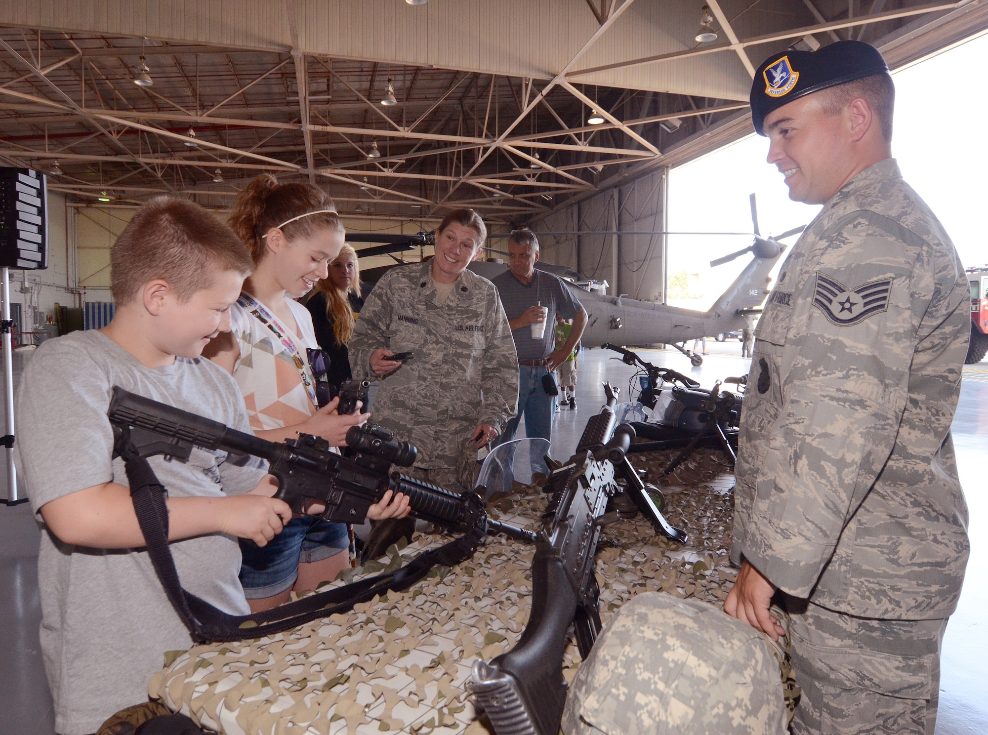 Staff Sgt. Adam Pollow answers questions from Garrett and Anna Manning about the small arms weapons displayed at the annual Bring Your Kids to Work Day at Dobbins Air Reserve Base, Jul. 27. Workers on Dobbins ARB were able to bring their kids to their places of work, then to a hangar with several hands-on displays of equipment utilized on the base and also to the C-130 flight simulator.  (U.S. Air Force photo/Brad Fallin)