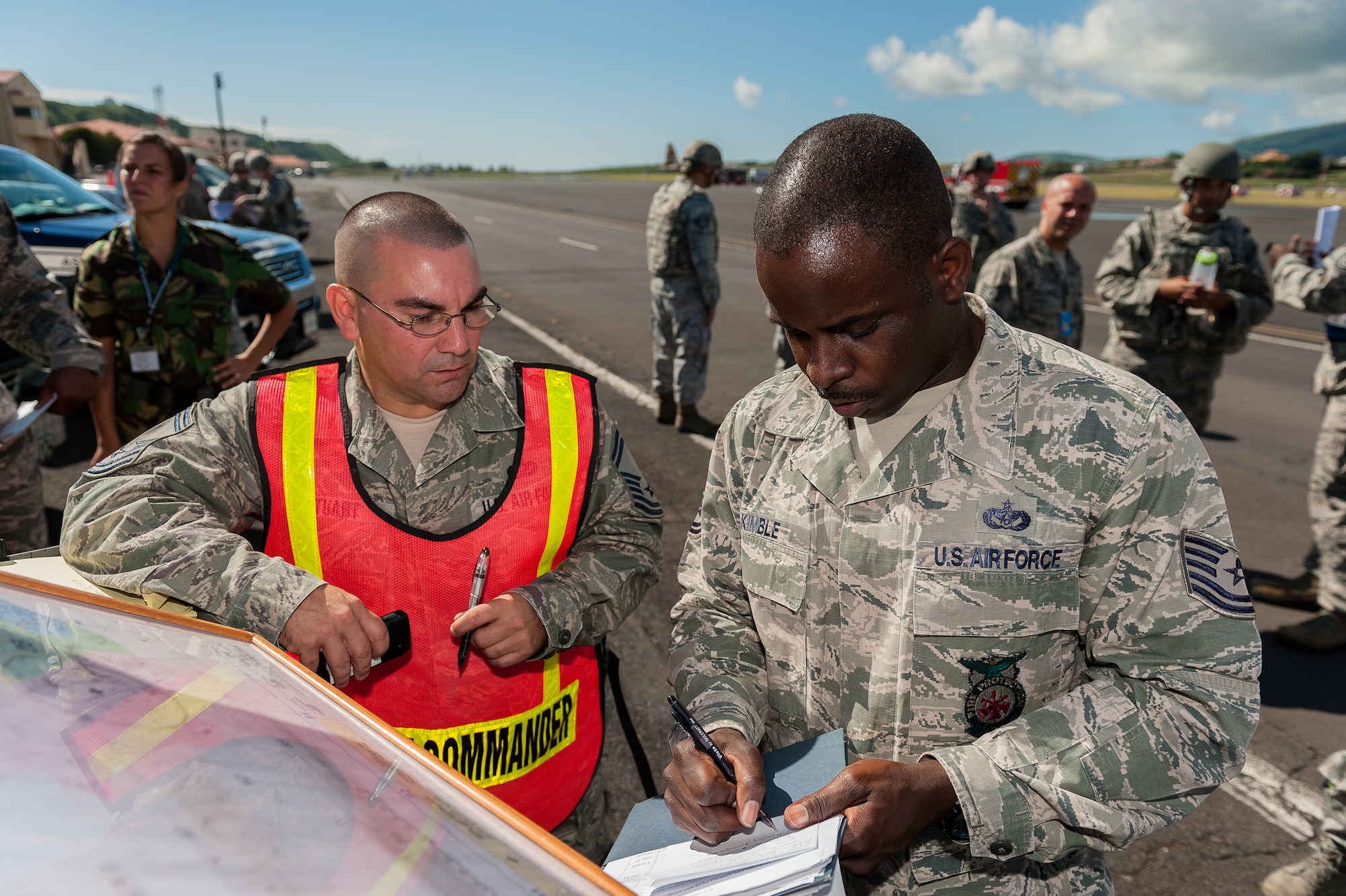 Senior Master Sgt. Robert Stuart, 65th Civil Engineer Squadron fire chief, explains his plan as the incident commander with Tech. Sgt. Floydzell Kimble, 65th CES exercise evaluator, during a joint exercise at Lajes Field, July 30 2012. Lajes Airmen teamed up with their Portuguese counterparts and practiced emergency procedures for a possible downed aircraft prior to the upcoming Open House on Aug. 5th
