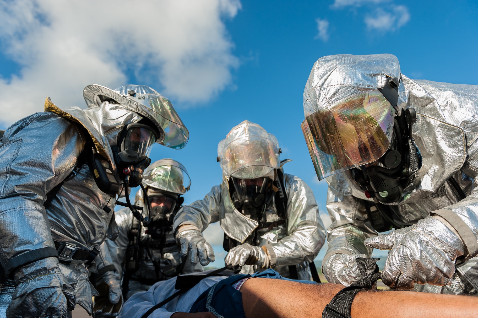 Firefighters from the 65th Civil Engineer Squadron secure a member with simulated injuries to a stretcher during a joint exercise at Lajes Field, July 30 2012.  Lajes Airmen teamed up their Portuguese counterparts and practiced emergency procedures for a possible downed aircraft prior to the upcoming Open House on Aug. 5th.  (Photo by Lucas Silva)