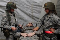 U.S. Air Force Senior Airmen Amanda Enfinger (left) and Nichole Thorton (right), 4th Medical Group medical technicians, take vital signs from Airman 1st Class Christopher Davis, 4th Aircraft Maintenance Squadron crew chief, during an operational readiness exercise on Seymour Johnson Air Force Base, N.C., July 26, 2012. Taking vital signs is part of initial procedures for treating injured personnel. (U.S. Air Force photo/Airman 1st Class John Nieves Camacho/Released)