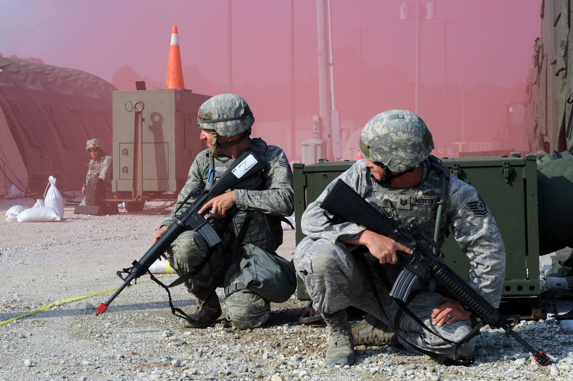 Airmen participating in an operational readiness exercise take cover after a smoke bomb was released on Seymour Johnson Air Force Base, N.C., July 26, 2012. OREs test Airmen’s ability to complete their mission in a deployed environment. (U.S. Air Force photo/Airman 1st Class John Nieves Camacho/Released)
