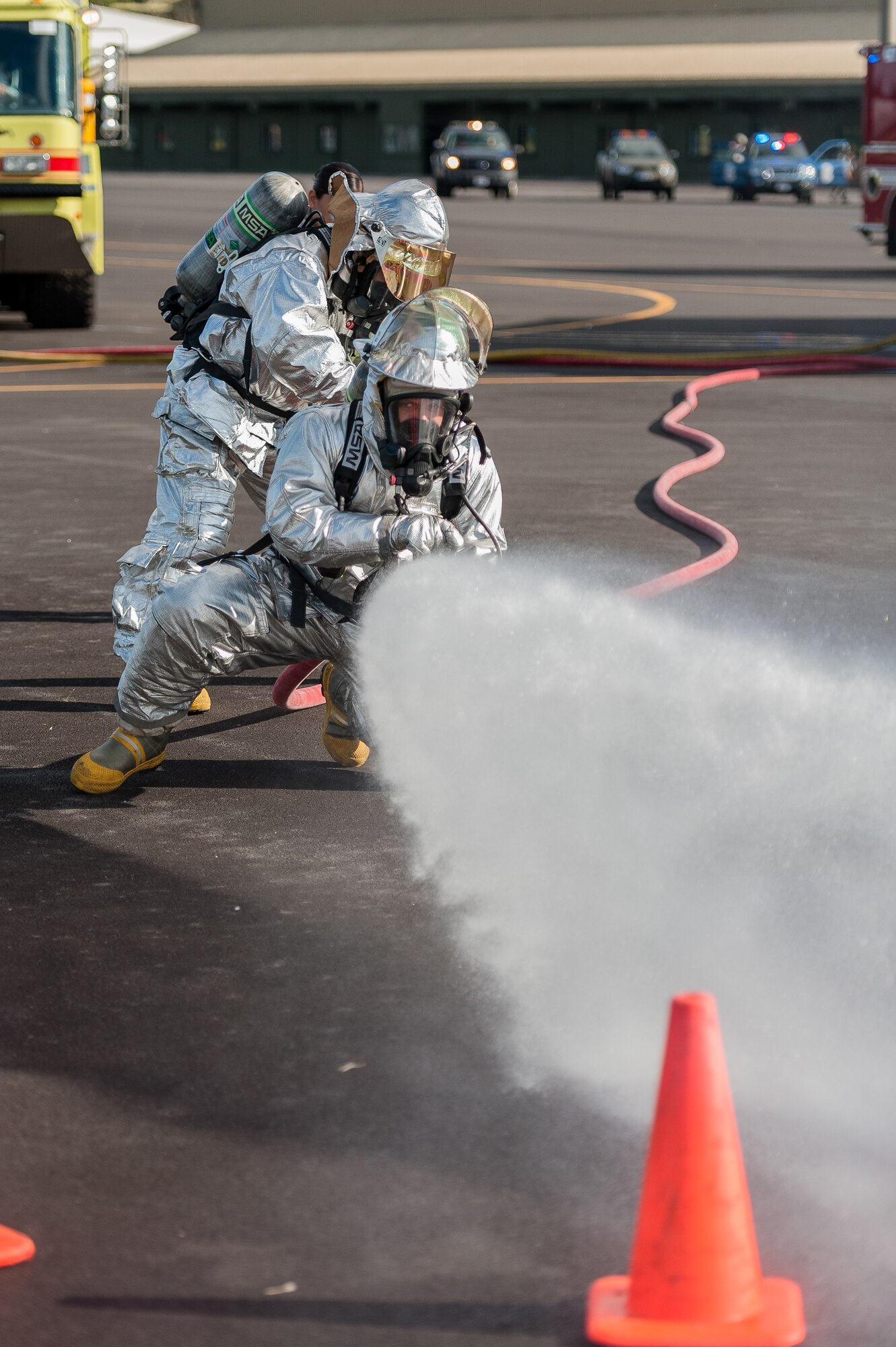 Firefighters  from the 65th Civil Engineer Squadron put out a simulated fire on an aircraft during an joint exercise at Lajes Field, July 30 2012. Lajes Airmen teamed up thier Portuguese counterparts and practiced for a worst case scenario prior to the upcoming Open House on August 5th. (Photo by Lucas Silva)