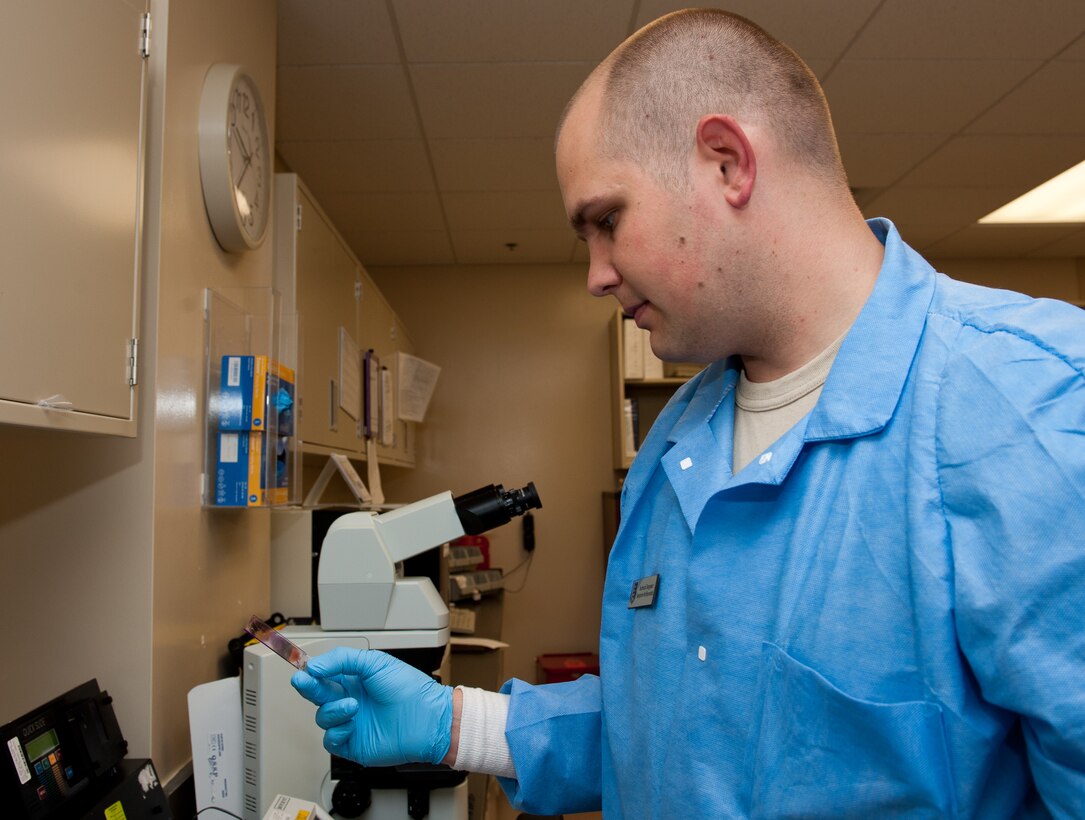 Tech. Sgt.  Benjamin McReynolds, 28th Medical Support Squadron laboratory operations NCO in charge, analyzes a slide of blood after staining it in the clinical laboratory on Ellsworth Air Force Base, S.D., July 27, 2012. The stain makes it easier to tell the difference between blood cells, problem cells and parasites, producing faster and more accurate results. (U.S. Air Force photo by Airman 1st Class Kate Thornton/Released) 