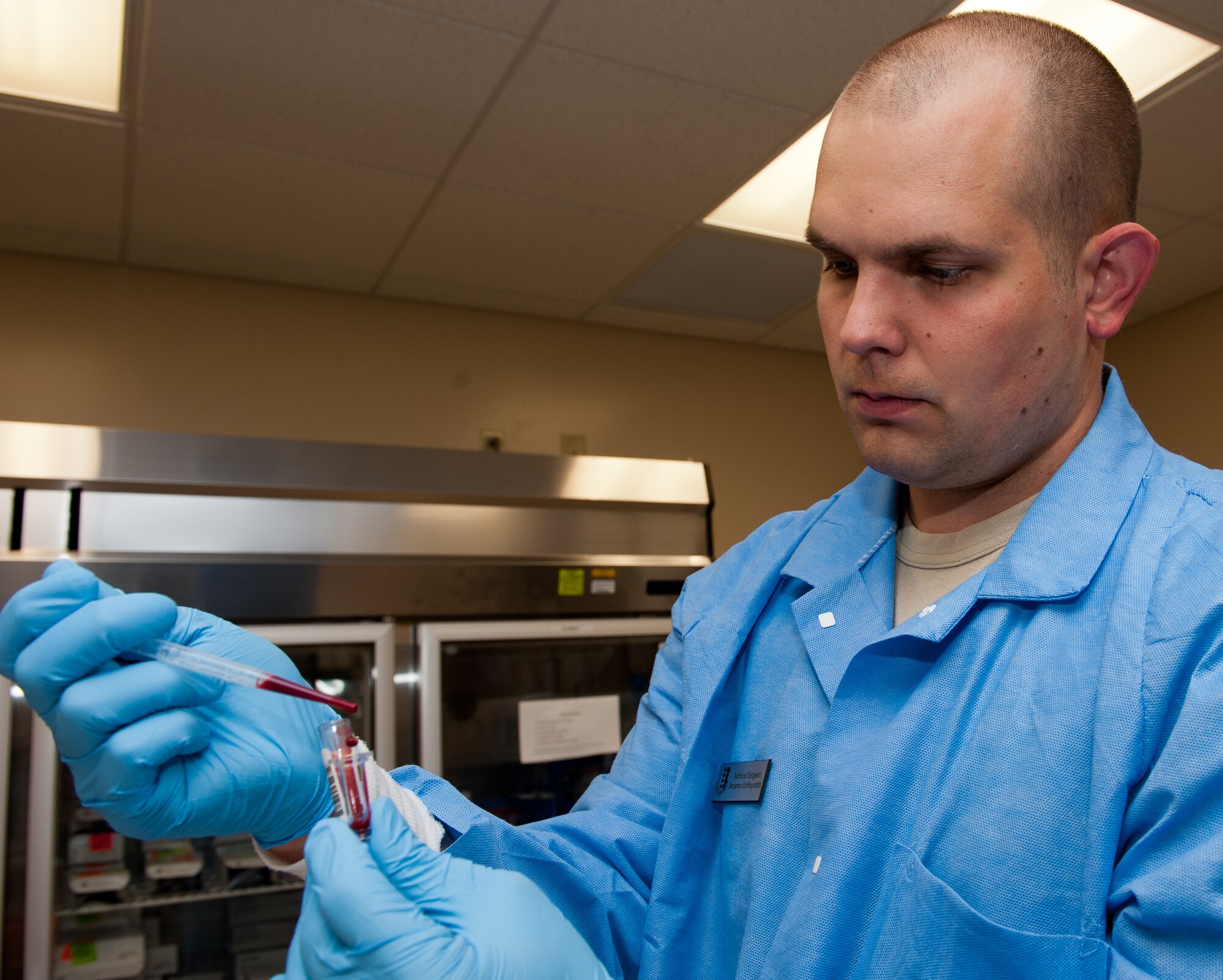 Tech. Sgt.  Benjamin McReynolds, 28th Medical Support Squadron laboratory operations NCO in charge, transfers blood from its original tube to a small sample cup before putting it into a chemistry analyzer in the clinical laboratory on Ellsworth Air Force Base, S.D., July 27, 2012. The chemical analyzer examines blood samples for amounts of various biological chemicals such as cholesterol, electrolytes, calcium, etc. (U.S. Air Force photo by Airman 1st Class Kate Thornton/Released)