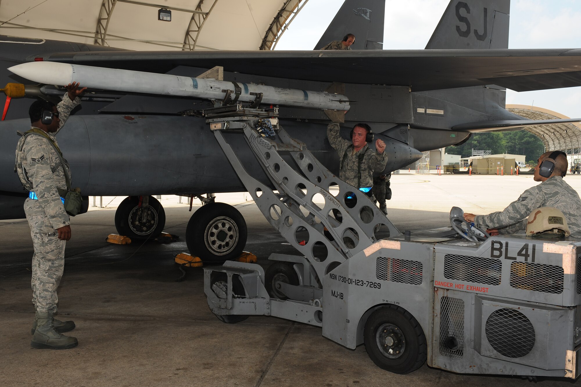 U.S. Air Force Senior Airman Michael Meza (right), 4th Aircraft Maintenance Squadron aircraft armament journeyman, raises an AIM-120 missile to be placed on an F-15E Strike Eagle while Airman 1st Class Manuel Wyley (left), 4th AMXS aircraft armament journeyman, and Staff Sgt. David Budine, 4th AMXS aircraft armament craftsman, hold it steady during an operational readiness exercise on Seymour Johnson Air Force Base, N.C., July 25, 2012. During the exercise, Airmen highlight their ability to position, employ and sustain forces in a deployed environment. (U.S. Air Force photo/Airman 1st Class John Nieves Camacho/Released)