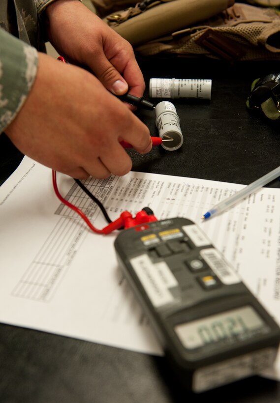 Airman 1st Class Christopher Mcgillis, 28th Operations Support Squadron aircrew flight equipment technician, tests the power of lithium batteries from an aircrew survival vest during a routine inspection at the 34th Bomb Squadron on Ellsworth Air Force Base, S.D., July 25, 2012. Each vest is equipped with two lithium batteries, one already in a radio and the other as a spare. Technicians inspect the batteries every 60 days to ensure they are operational and are properly charged. (U.S. Air Force photo by Airman 1st Class Kate Thornton/Released)