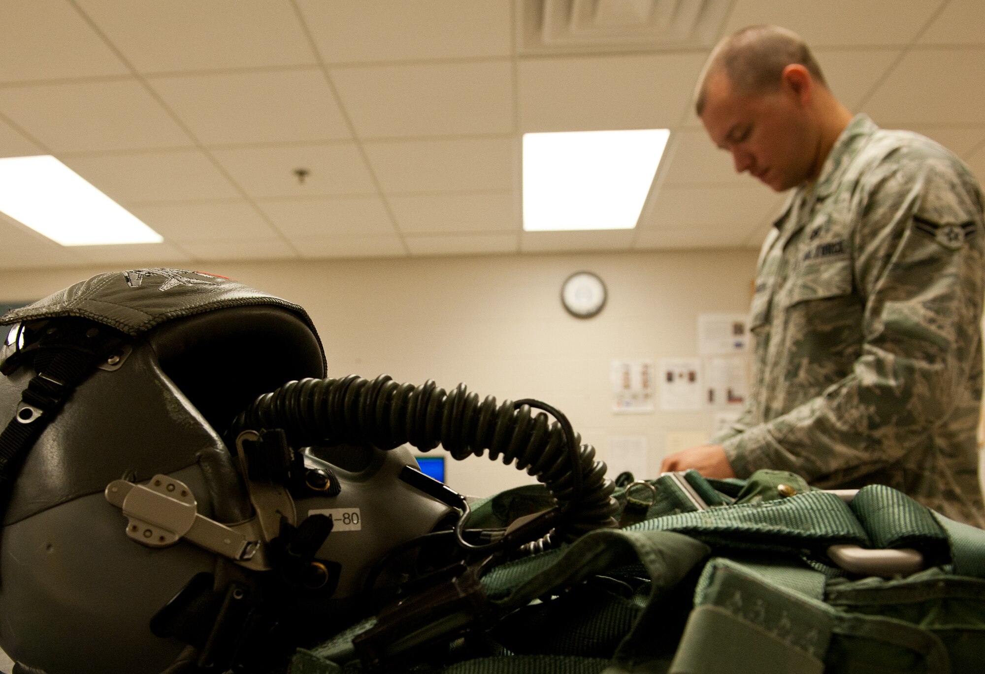 Airman 1st Class Christopher Mcgillis, 28th Operations Support Squadron aircrew flight equipment technician, removes items from an aircrew survival vest during a routine inspection at the 34th Bomb Squadron on Ellsworth Air Force Base, S.D., July 25, 2012. AFE technicians maintain aircrew equipment such as survival gear, parachutes, flight helmets with masks, harnesses, and various types of goggles and glasses used by aircrews. (U.S. Air Force photo by Airman 1st Class Kate Thornton/Released)