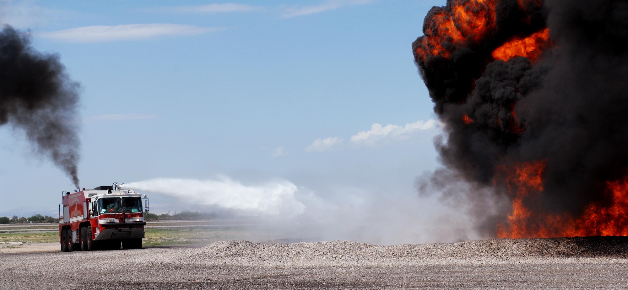 U.S. Air Force members of the 355th Civil Engineer Squadron Fire and Emergency Services Flight use the handline  to extinguish a fire during a training session at the D-M Regional Fire and Emergency Services Training Area on Davis-Monthan Air Force Base, Ariz., July 17, 2012. The almost five acre training ground houses mock aircraft, a simulated roof, buildings with different layouts and a vehicle extraction pad. (U.S. Air Force photo by Airman 1st Class Saphfire Cook)