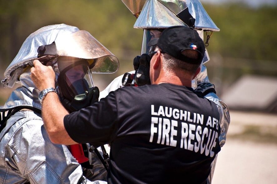 A Laughlin firefighter suits up before participating in a live-fire training exercise at Laughlin Air Force Base, Texas, July 24, 2012. The fire department conducted their first day of hands-on training with the new P-34 Rapid Intervention Vehicle. The Air Force is switching to the new vehicle because of its high foam and water pressure combination is more effective than the older P-19 vehicle. (U.S. Air Force photo/Senior Airman Scott Saldukas)