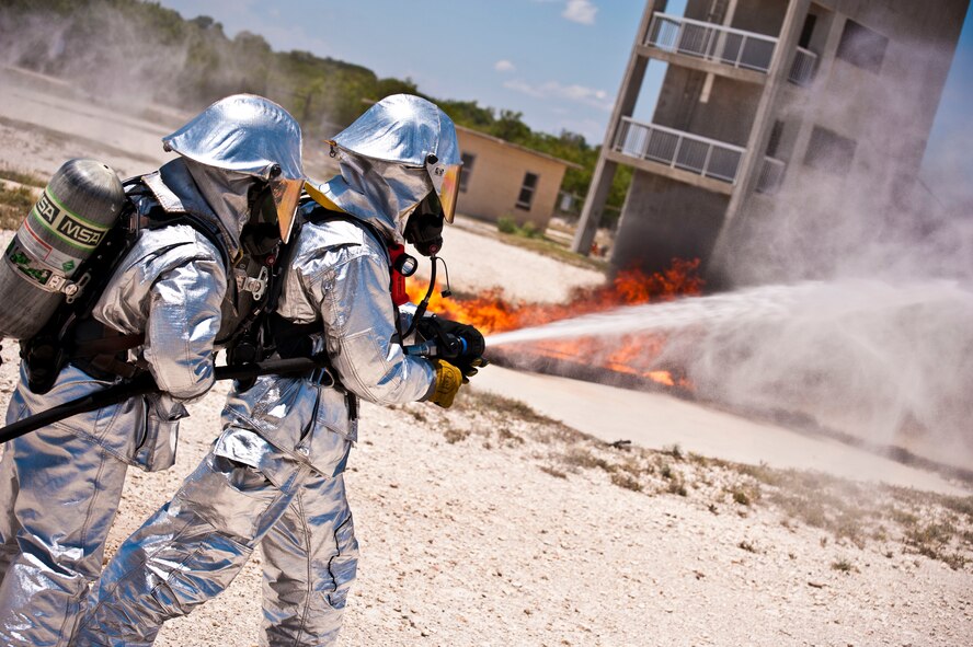 A team of firefighters attempt to smother a fire during a training exercise at Laughlin Air Force Base, Texas, July 24, 2012. The fire department conducted their first day of hands-on training with the new P-34 Rapid Intervention Vehicle. The Air Force is switching to the new vehicle because of its high foam and water pressure combination is more effective than the older P-19 vehicle. (U.S. Air Force photo/Senior Airman Scott Saldukas)