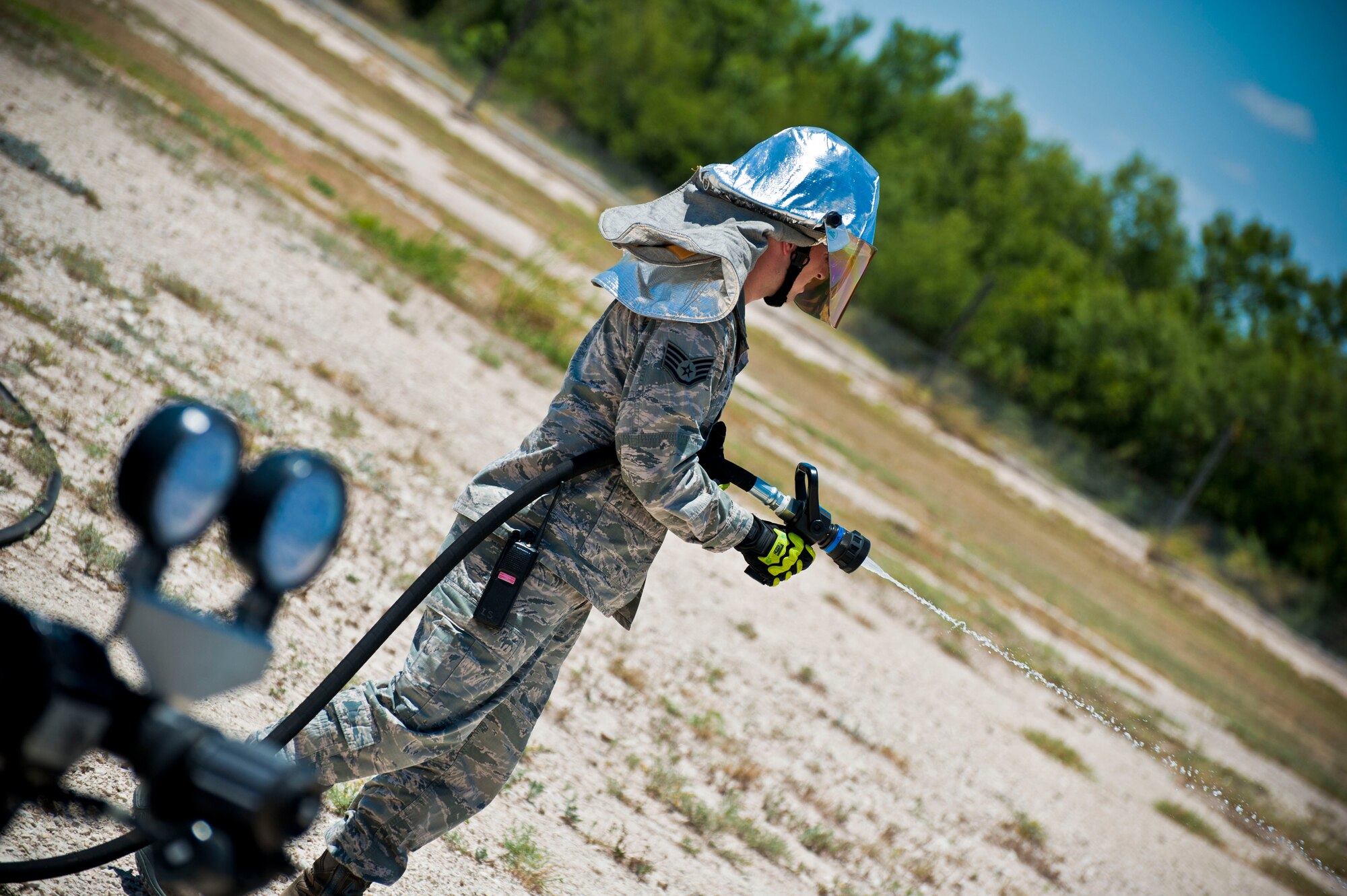 An Air Force staff sergeant from the Laughlin Fire Department tests a fire hose before participating in a training exercise at Laughlin Air Force Base, Texas, July 24, 2012. The fire department conducted their first day of hands-on training with the new P-34 Rapid Intervention Vehicle. The Air Force is switching to the new vehicle because of its high foam and water pressure combination is more effective than the older P-19 vehicle. (U.S. Air Force photo/Senior Airman Scott Saldukas)