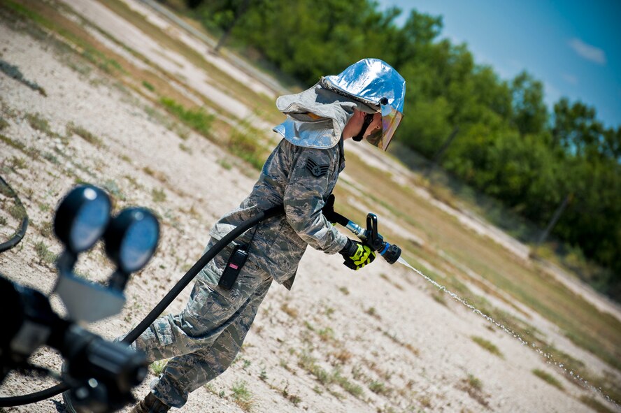 An Air Force staff sergeant from the Laughlin Fire Department tests a fire hose before participating in a training exercise at Laughlin Air Force Base, Texas, July 24, 2012. The fire department conducted their first day of hands-on training with the new P-34 Rapid Intervention Vehicle. The Air Force is switching to the new vehicle because of its high foam and water pressure combination is more effective than the older P-19 vehicle. (U.S. Air Force photo/Senior Airman Scott Saldukas)