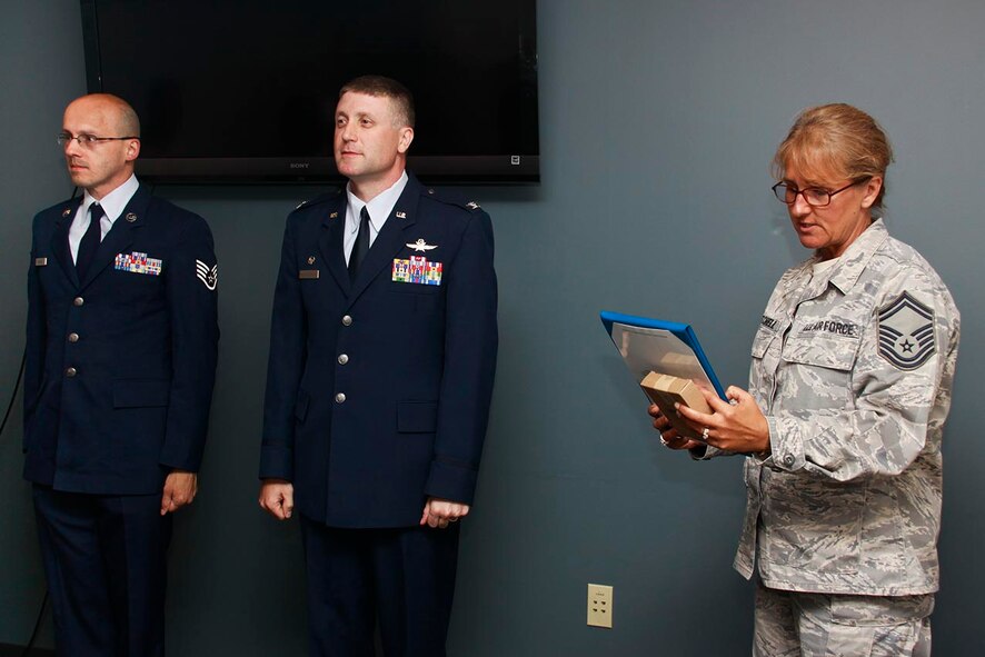 Staff Sgt. Brian Barnes (left), a 911th Airlift Wing cyber operations specialist, and Col. Patrick S. Ryan, Maintenance Support Group commander, stand at the position of attention while Senior Master Sgt. Brenda Mitchell states the orders for Barnes’ Air Force Commendation Medal, July 30, 2012. Authorized by the Secretary of the Air Force on March 28, 1958, the Air Force Commendation Medal is given to any Airman serving after March 24, 1958 who distinguished themselves by meritorious achievement and service and Barnes exemplified these qualities with the 911th AW Communications Squadron. Barnes’ knowledge and expertise led to 100 percent mission accomplishment of the Joint Incident Site Communications Capability Joint Task Force Razorback. (U.S. Air Force photo by Senior Airman Justyne Obeldobel/Released)