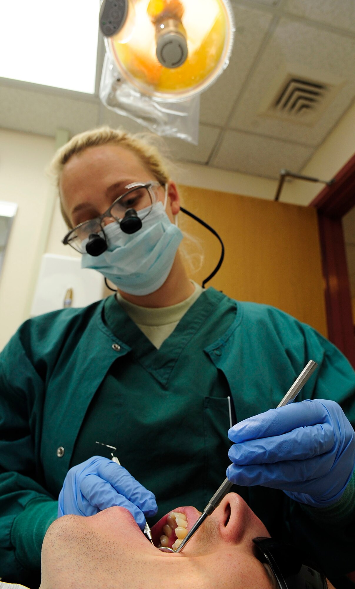 RAF MILDENHALL, England – Capt. (Dr.) Julie Robinson, 48th Dental Squadron, performs a routine exam during an internal training exercise on Senior Airman Phillip Madison, 48th Dental Squadron dental technician, at RAF Mildenhall July 30, 2012. The RAF Mildenhall dental clinic roughly sees 200 patients weekly. (U.S. Air Force photo Senior Airman Ethan Morgan)