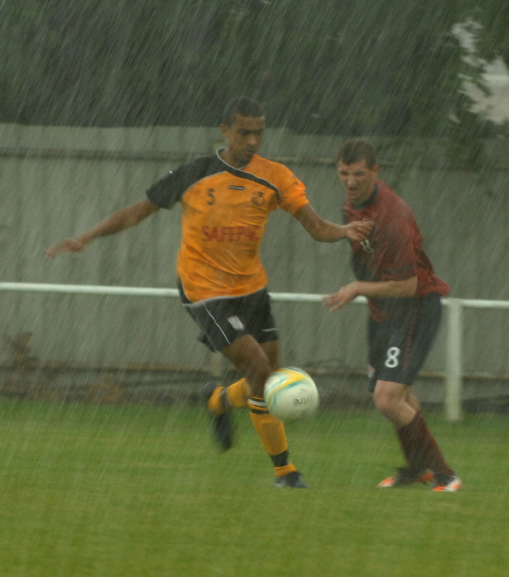 MILDENHALL, England – A player from the Mildenhall Town Football Club, in the yellow uniform dribbles the ball away from an RAF Mildenhall soccer team player during a soccer match July 29, 2012 at the MTFC pitch in Mildenhall. The semi-professional team, MTFC won the match with a score of 14-1. (U.S. Air Force photo/Senior Airman Rachel Waller)