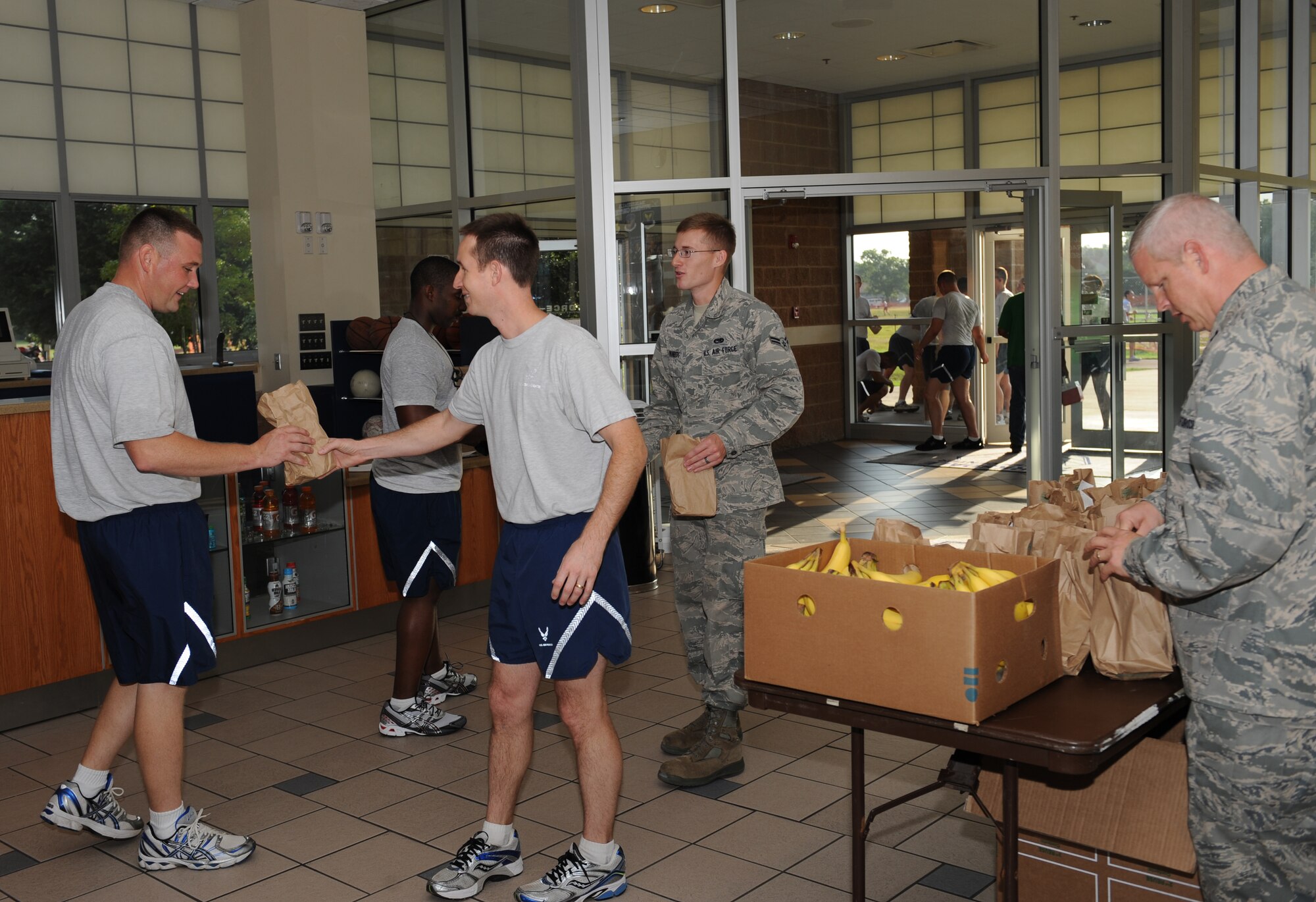 Team Barksdale members hand out breakfast bags to Airmen at the fitness center on Barksdale Air Force Base, La., July 30. The base Chaplains and volunteers gave out breakfast bags to help raise morale among base Airmen and provide for those who didn't have enough time to get breakfast themselves. The event also gave Airmen an opportunity to socialize with their Chaplains. (U.S. Air Force photo/Airman 1st Class Benjamin Gonsier)(RELEASED)

