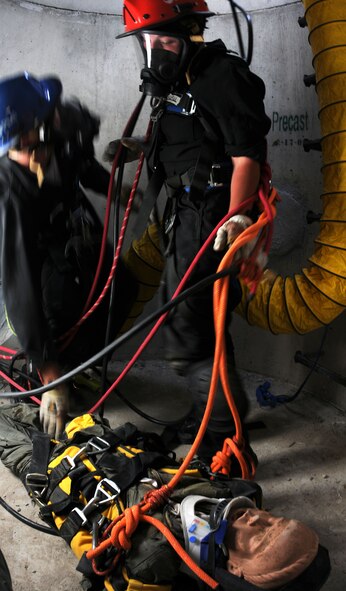 Senior Airman Justin Erikson (left), 21st Civil Engineer Squadron firefighter from Peterson Air Force Base, and Staff Sgt. Nicole Longwell (right), 10th Civil Engineer Squadron firefighter, assess the “victim” during the hands-on portion of the confined space training July 26 as part of Rescue 1 Technician course. The course is an advanced course designed for Department of Defense firefighters to teach them ropes courses, low-angles, high line systems and confined spaces. (U.S. Air Force photo/Staff Sgt. Julius Delos Reyes)