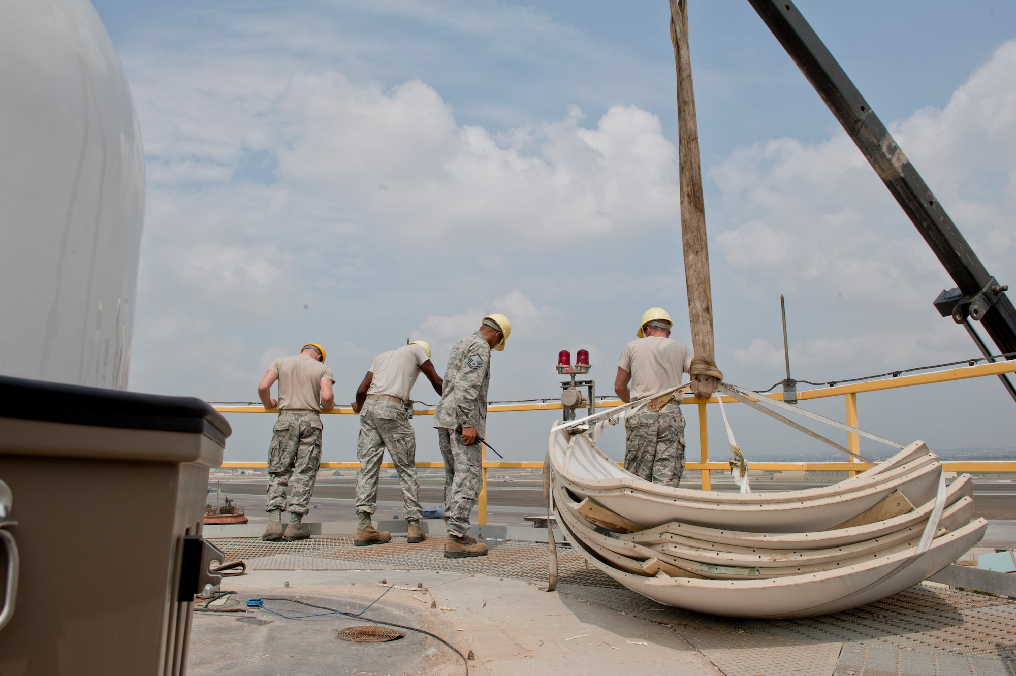 Airmen from the 39th Communications Squadron ground radar maintenance section, watch the crane operators as they lift the old Tactical Weather Radar system off the 77-foot weather tower July 27, 2012, at Incirlik Air Base, Turkey. The TWR was replaced with the new Portable Doppler Radar system, first in U.S. Air Forces in Europe and the new system will enhance weather predictability for both U.S. and Turkish forces at Incirlik. (U.S. Air Force photo by Senior Airman Anthony Sanchelli/Released) 
