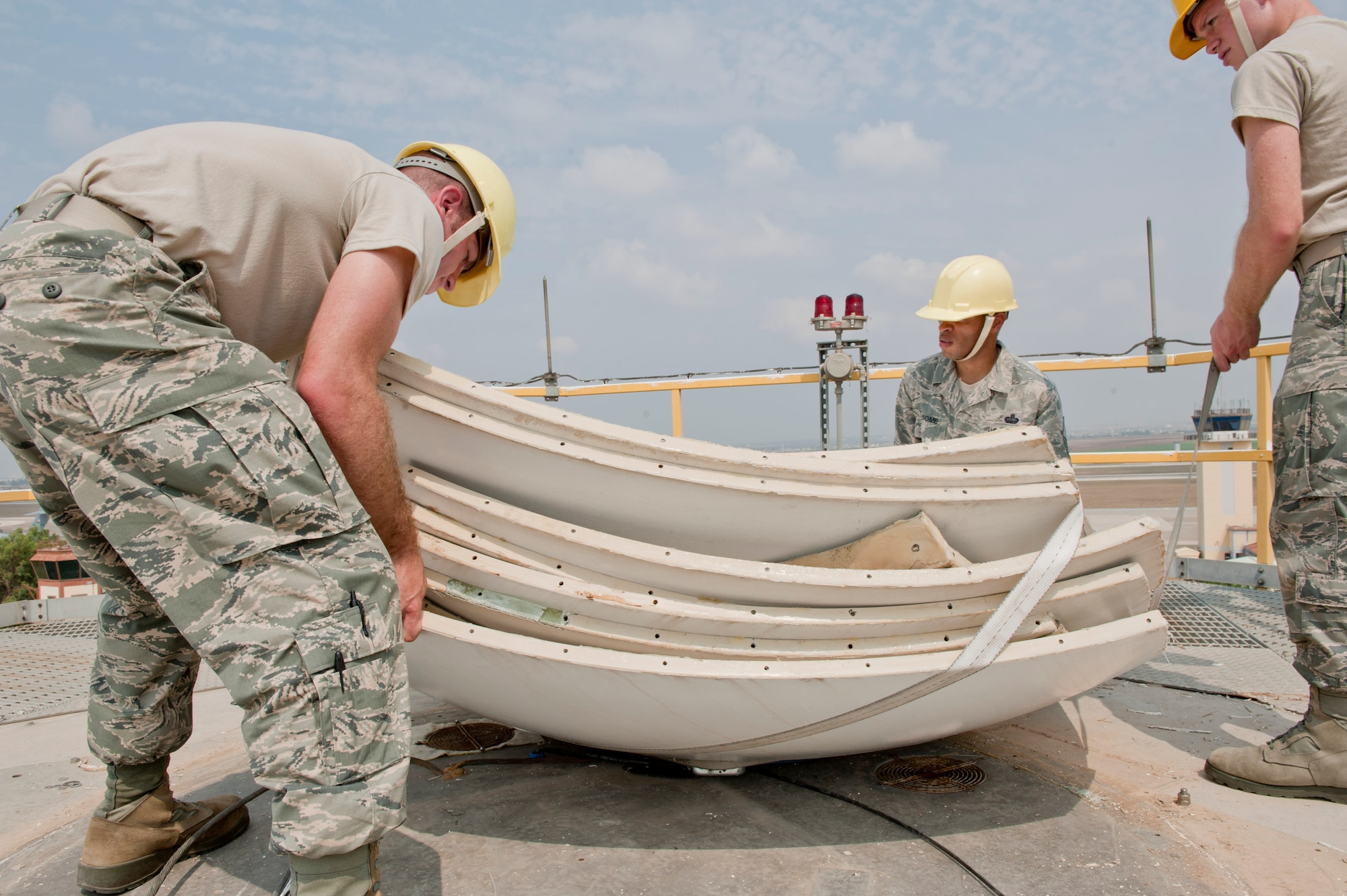 Airmen from the 39th Communications Squadron ground radar maintenance section, fasten straps around the old Tactical Weather Radar dish July 27, 2012, at Incirlik Air Base, Turkey. The old system was replaced with the new Portable Doppler Radar system and will enhance weather predictability for both U.S. and Turkish forces at Incirlik. (U.S. Air Force photo by Senior Airman Anthony Sanchelli/Released) 
