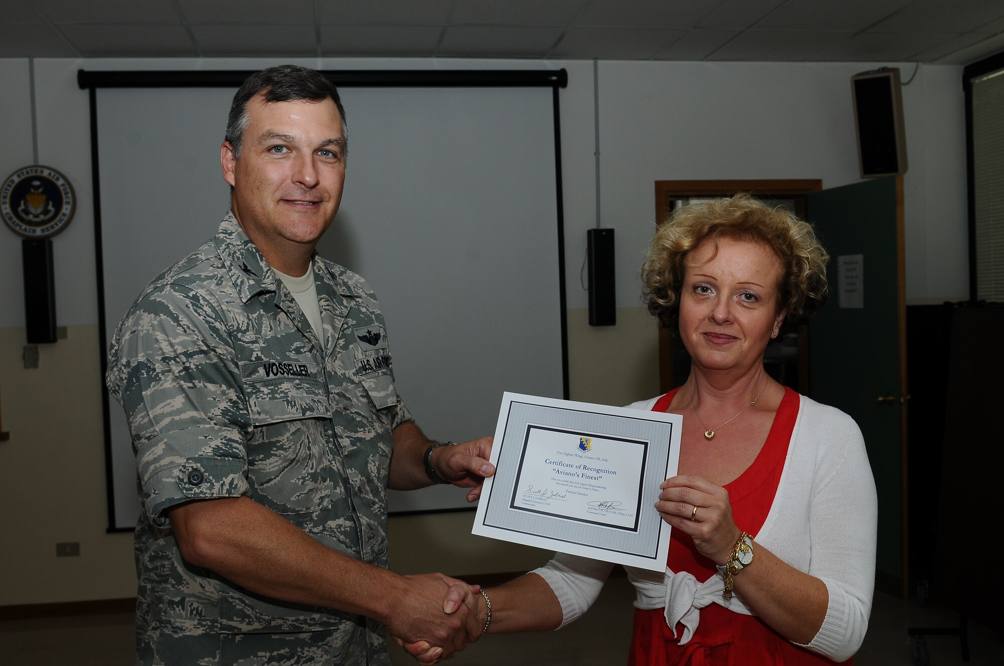 Col. Brent Vosseler, 31st Fighter Wing vice commander, recognizes Patrizia Danelon, 31st Medical Support Squadron management analyst, as one of Aviano's Finest July 26, at Aviano Air Base.  Aviano's Finest is a commanders recognition program that identifies and honors Aviano Airmen for their work ethic, professinalism and commitment to the mission.(U.S. Air Force photo by Staff Sgt. Ryan Whitney)