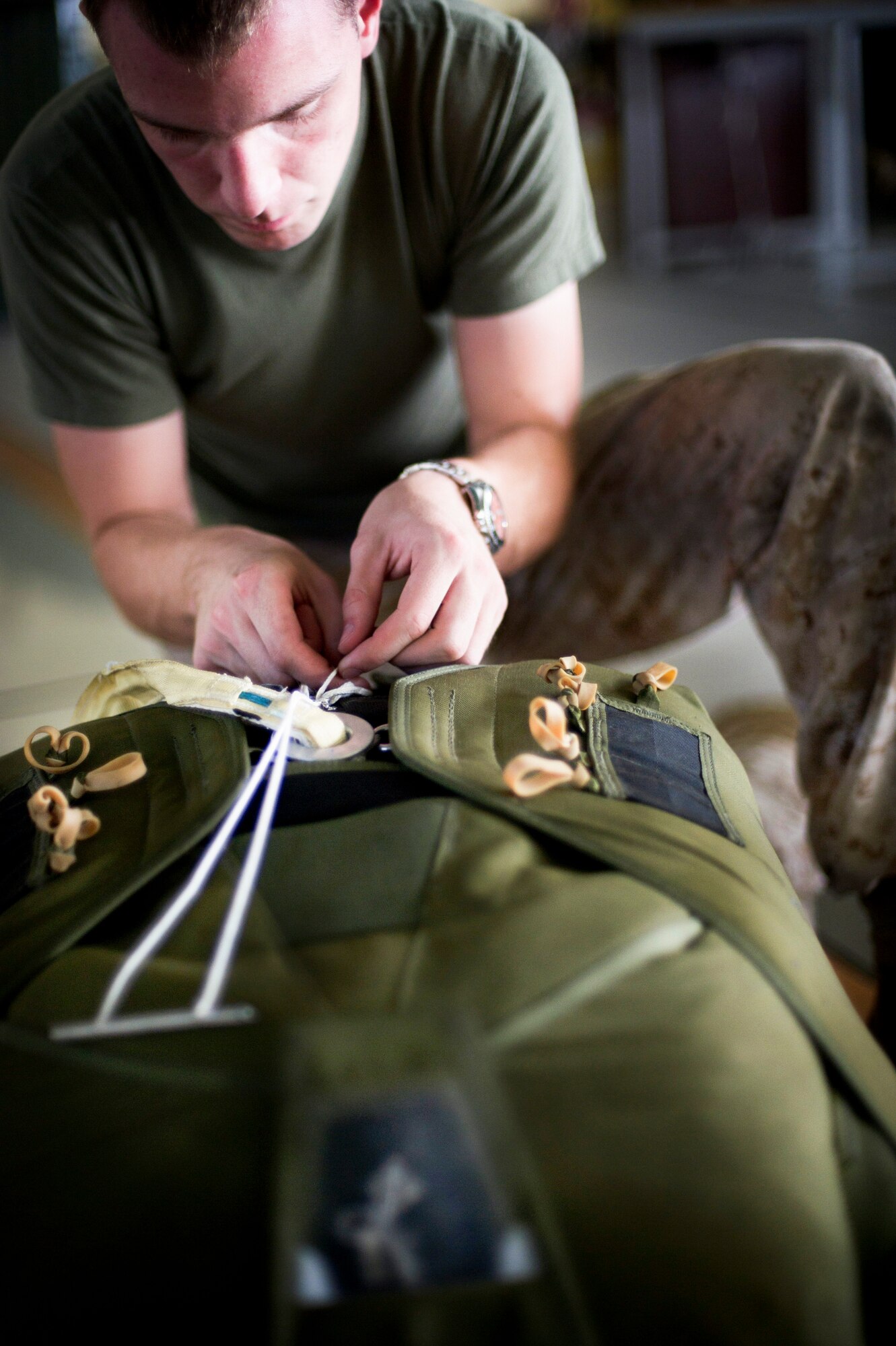 YOKOTA AIR BASE, Japan -- A Marine parachute rigger assigned to the 31st Marine Expeditionary Unit from Okinawa, Japan, inspects a parachute before he gives it to a paratrooper on July 26, 2012 at Yokota Air Base, Japan. Every parachute is inspected multiple times before it is used to ensure the highest safety standards for the jumper. (U.S. Air Force photo by Staff Sgt. Stacy Moless)