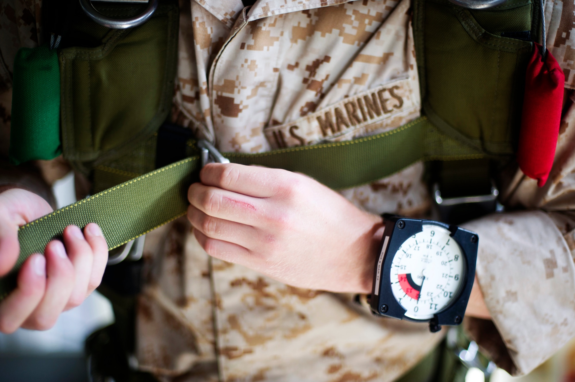 YOKOTA AIR BASE, Japan -- A Marine paratrooper assigned to the 31st Marine Expeditionary Unit from Okinawa, Japan, tightens his parachute strap July 25, 2012 at Yokota Air Base, Japan. The unit spent the week working on their parachute qualifications practicing static line and high-altitude, low-opening jumps. (U.S. Air Force photo by Staff Sgt. Stacy Moless)