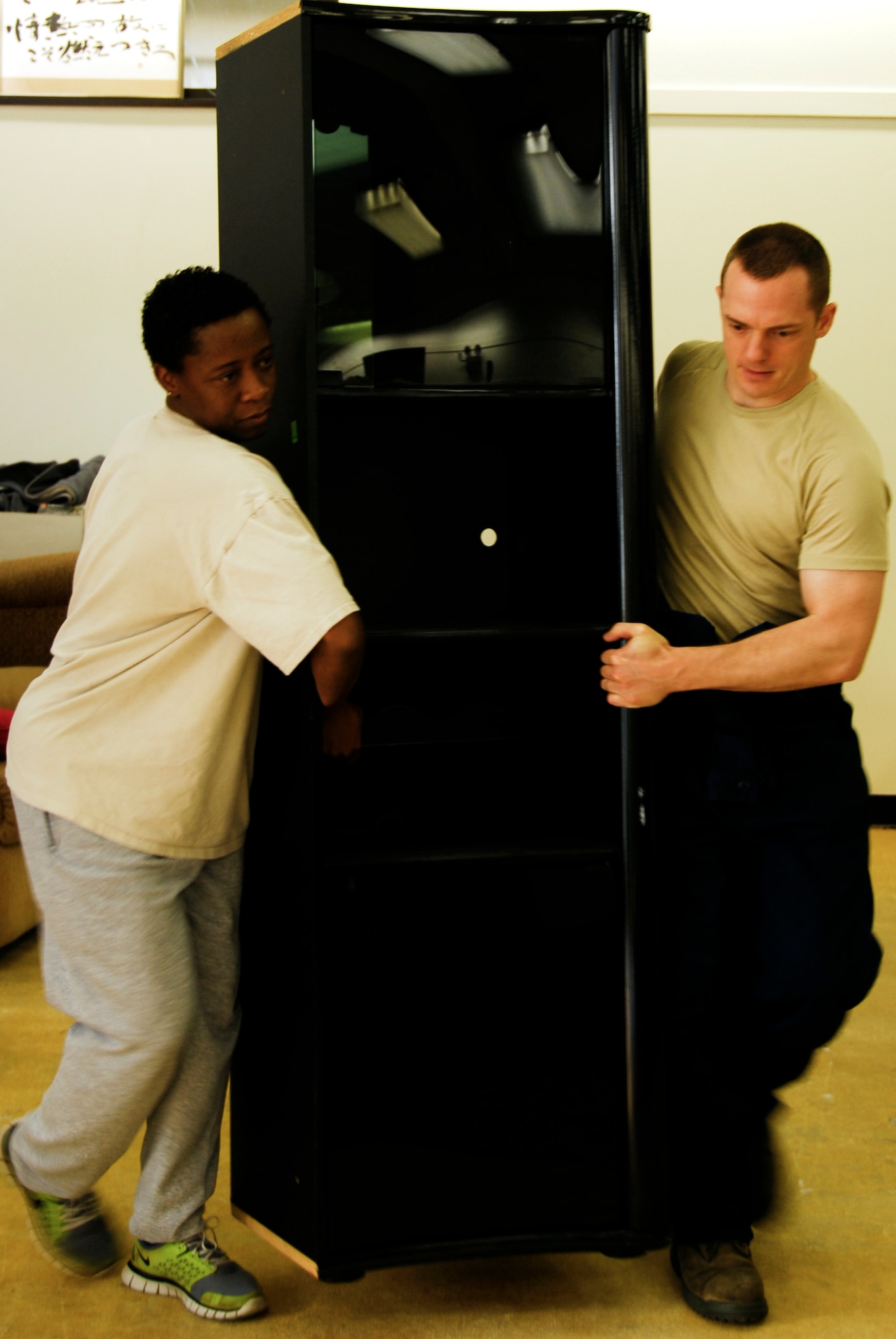 YOKOTA AIR BASE, Japan -- Master Sgt. Cynthia Lane, left, 374th Security Forces Squadron NCO in charge of police services, and Staff Sgt. Clayton Lochman, 374th Maintenance Squadron aerospace proportion craftsman, move a cabinet at the Airman’s Attic at Yokota Air Base, Japan, July 26, 2012. Volunteers helped remodel the Airman’s Attic in an effort to brighten the appearance by putting down new carpet, painting and re-organizing the store. (U.S. Air Force photo by Senior Airman Lynsie Nichols)
