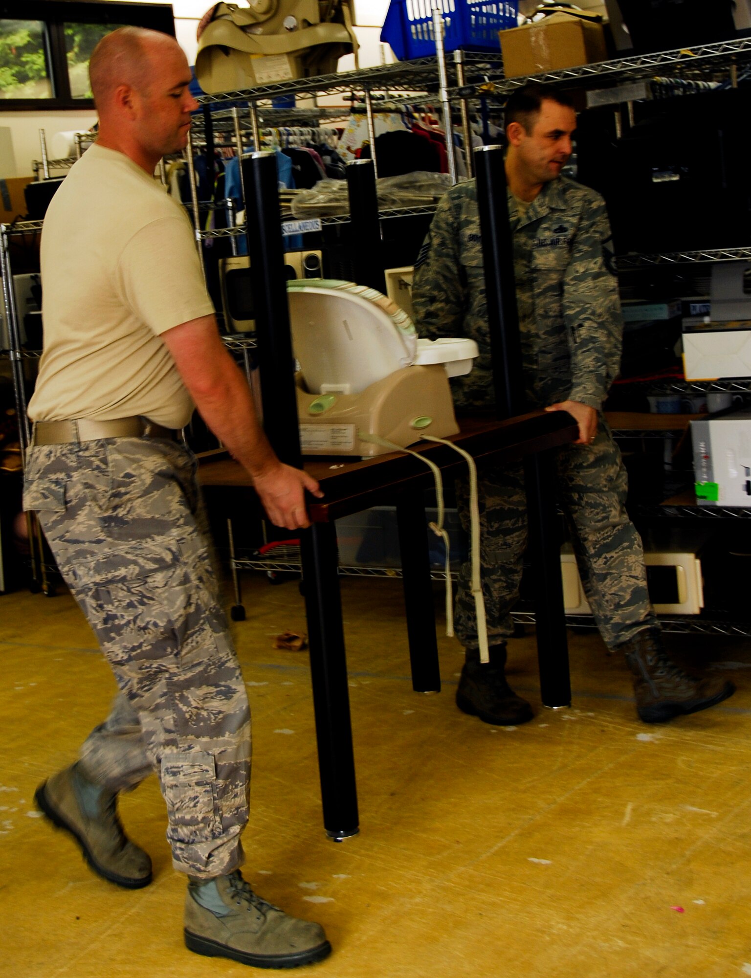 YOKOTA AIR BASE, Japan -- Master Sgt. Michael Deidrich, left, 374th Airlift Wing Plans and Programs superintendent of wing plans and exercises, and Master Sgt. Anthony Boyer, 374th Maintenance Squadron maintenance flight chief, move a table at the Airman’s Attic at Yokota Air Base, Japan, July 26, 2012. The Airman’s Attic is a second had shop available to all Sofa status ID card holders. (U.S. Air Force photo by Senior Airman Lynsie Nichols)