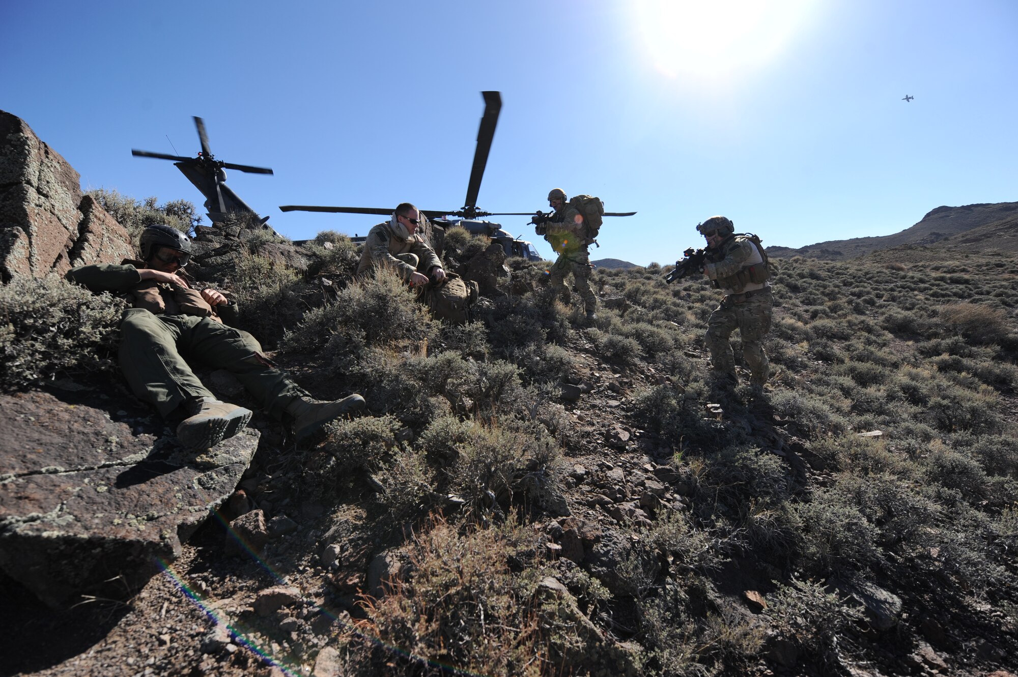 U.S. Air Force Senior Airman Ronny Epps and Staff Sgt. Matthew Ritchie, pararescuemen from the 58th Rescue Squadron at Nellis Air Force Base, Nev., confirm the identity of a downed aircrew member during a combat search and rescue scenario for exercise Red Flag 12-4, July 24, 2012 at the Nevada Test and Training Range.  After confirming the pilot's identity, the Airmen treated his simulated wounds and escorted him to the waiting HH-60 Pave Hawk. (U.S. Air Force photo by Master Sgt. Sonny Cohrs) 