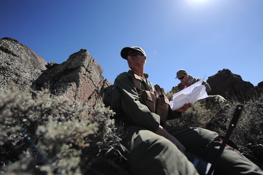 U.S. Air Force 1st Lt. Kyle Harrington, a B-1 bomber pilot with the 34th Bomb Squadron at Ellsworth Air Force Base, S.D., gets his bearings during a combat search and rescue exercise July 24, 2012, at the Nevada Test and Training Range for Red Flag 12-4.  Harrington used a radio, signaling mirror and smoke canister to signal recovery aircraft in the area.  (U.S. Air Force photo by Master Sgt. Sonny Cohrs) 