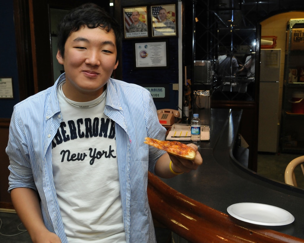 Tak, Hyo-jun, an 18-year-old high school student from Busan enjoys pizza at an event on U.S. Army Garrison Yongsan. Tak spent a week with Brenda Dunwoody, Legal Technician at the U.S. Army Corps of Engineers, Far East District Office of Counsel, and her family during the U.S. Forces Korea Good Neighbor Program English Camp May 15-21. (Photo by Patrick Bray)