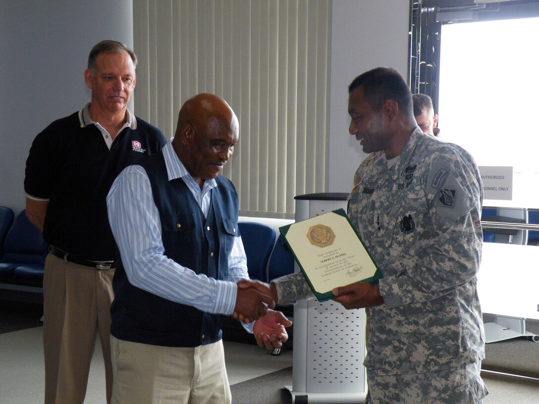 Al Mathis, civil engineer and technician at Iwakuni Resident Office, is congratulated for 40 years of service, 34 years with the U.S. Army Corps of Engineers and six years of active military service, by Lt. Gen. Thomas P. Bostick, commanding general, USACE during the general's visit to Marine Corps Air Station, Iwakuni, Japan July 19 as Lee Seeba, Iwakuni program director/resident engineer looks on. (Official USACE photo)