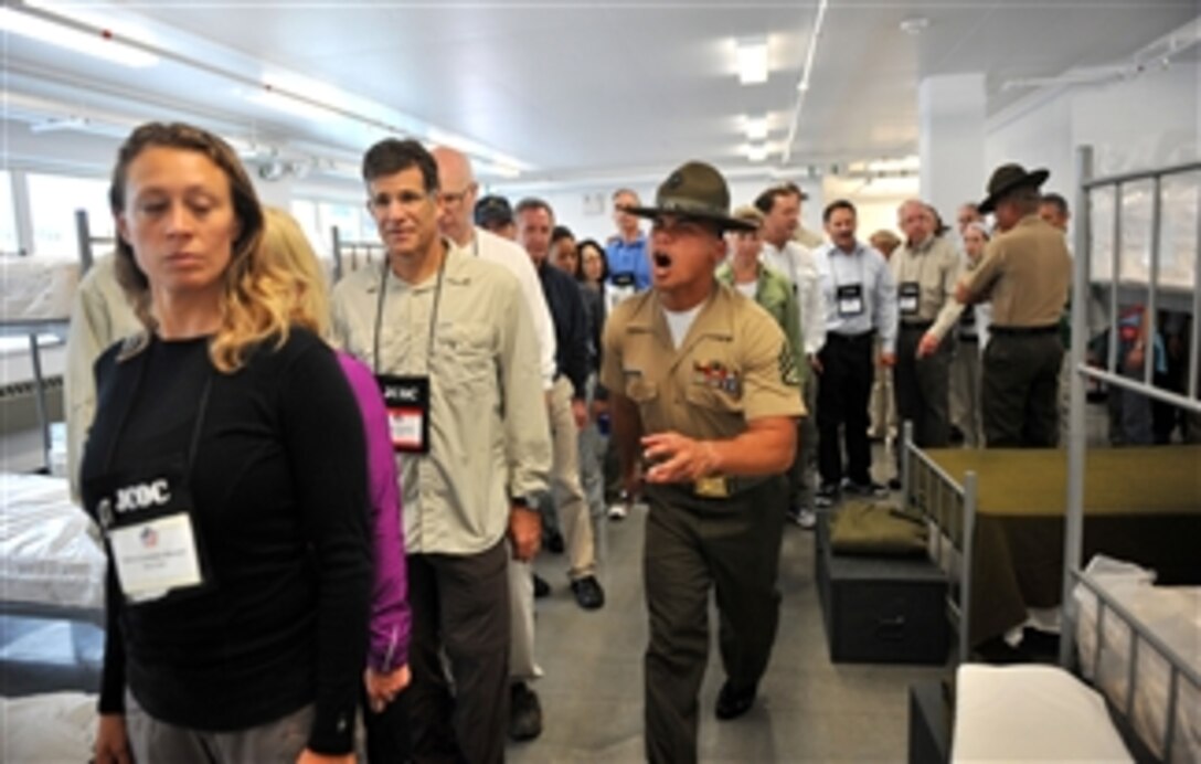 Participants of the DoD's Joint Civilian Orientation Conference receive the close attention of a drill instructor at the Marine Corps Recruit Depot in San Diego on July 25, 2012.  The participants were surprised by the stern welcome given to them as they were treated to a standard new recruit shakedown at the base's receiving barracks.  