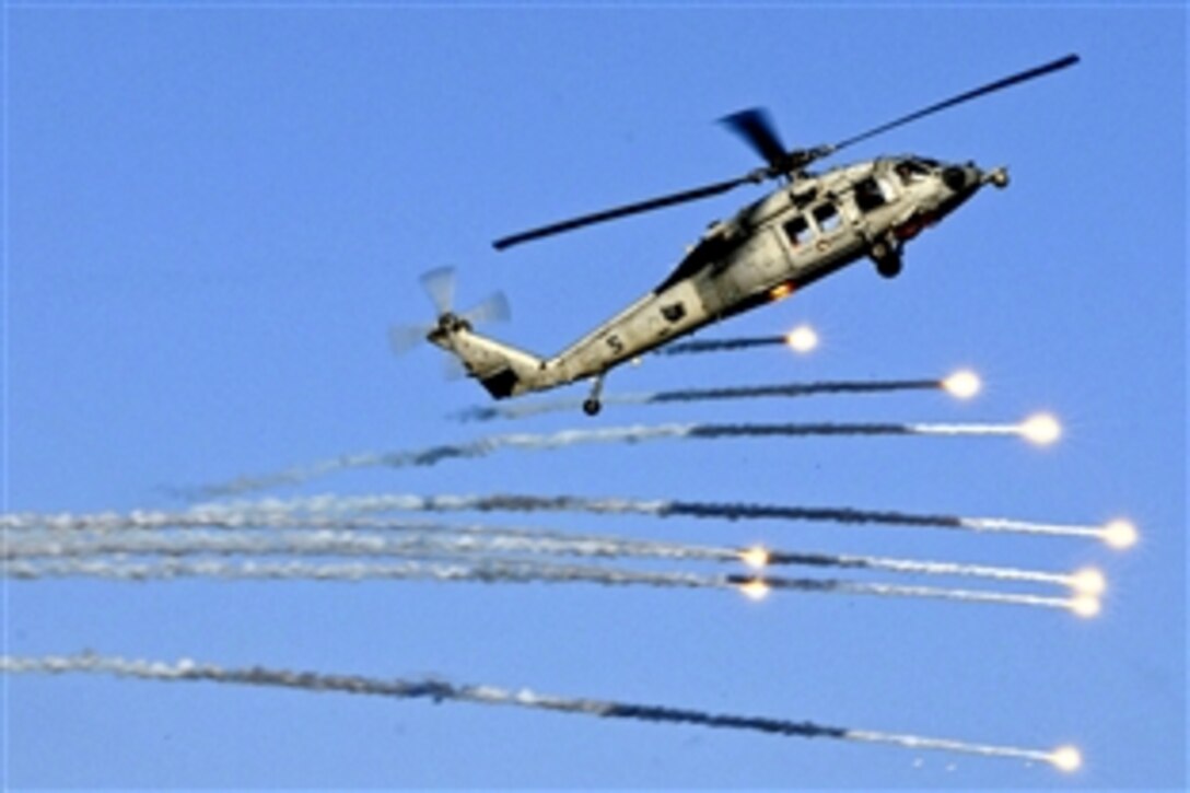 An MH-60S Seahawk helicopter launches flares during practice for an upcoming demonstration in the skies above the aircraft carrier USS Abraham Lincoln under way in the Mediterranean Sea, July 25, 2012. The helicopter crew is assigned to Helicopter Sea Combat Squadron 12. The Lincoln is on a scheduled deployment to support maritime security operations and theater security cooperation efforts in the U.S. 6th Fleet area of responsibility.