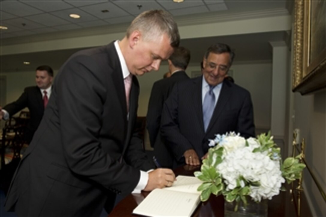 Secretary of Defense Leon Panetta stands with Polish Minister of Defense Tomasz Siemoniak as he signs a guest book prior to meeting in the Pentagon on July 25, 2012.  Panetta, Siemoniak and their senior staff will meet to discuss issues of mutual interest to both nations.  