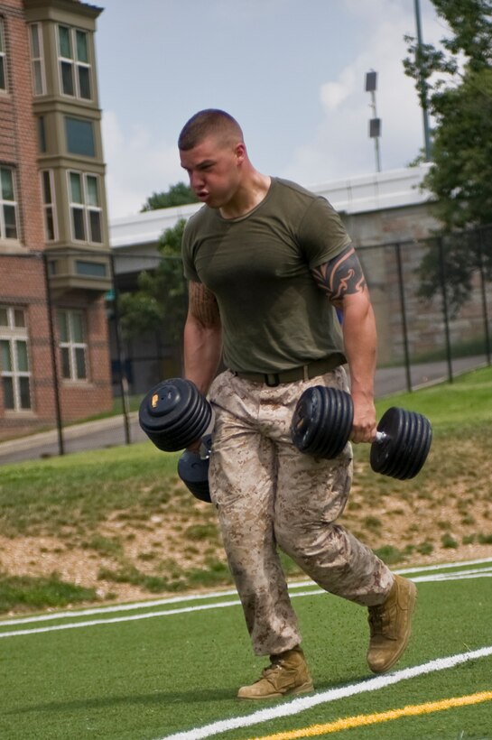 Lance Cpl. John Hartley, Marine Corps body bearer and native of Kalama, Wash., carries two 120-pound dumbbells during Musclefest at Marine Barracks Washington July 30. Competitors had to carry two dumbbells totaling their body weight for 100 yards. Musclefest is the sixth 2012 Commander’s Cup event.  Four scheduled events remain this year.