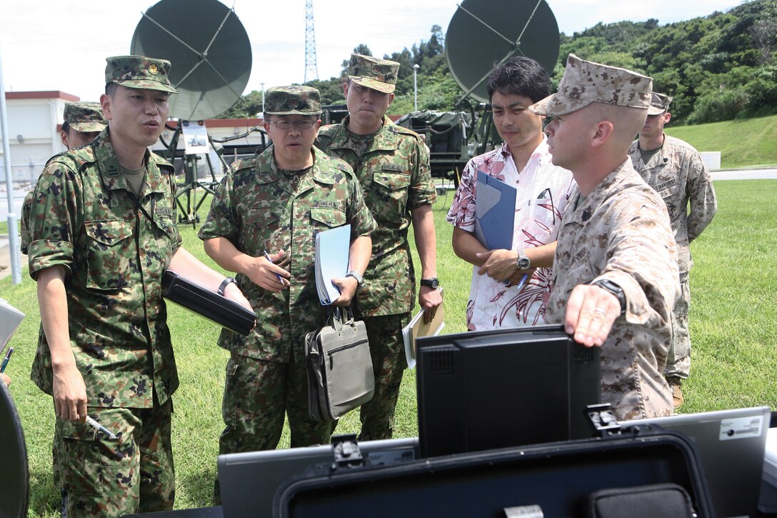 Cpl. Mitchell D. McMillion shows members of the Western Army Signal Group, Japan Ground Self-Defense Force, equipment for a radio data team kit at Camp Hansen June 27. The kit was shown to give JGSDF members an idea of Marine Corps expeditionary command and control capabilities. The purpose of the group's visit was to compare the capabilities of Marine Corps and JGSDF equipment. McMillion is a tropospheric scatter radio multi-channel equipment operator with 7th Communication Battalion, which is part of III Marine Expeditionary Force Headquarters Group, III MEF.

