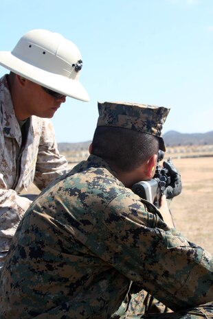 Cpl. Francisco Cortes, marksmanship coach, Weapons Company, Weapons and Field Training Battalion, gives Recruit Mathew Guzman, Platoon 1025, Co. B, tips as he prepares to fire the M16-A4 service rifle at Edson Range aboard Marine Corps Base Camp Pendleton, Calif. The coaches aboard Edson Range are trained to help guide, instruct and train each recruit how to apply the fundamentals of marksmanship during Firing Week.