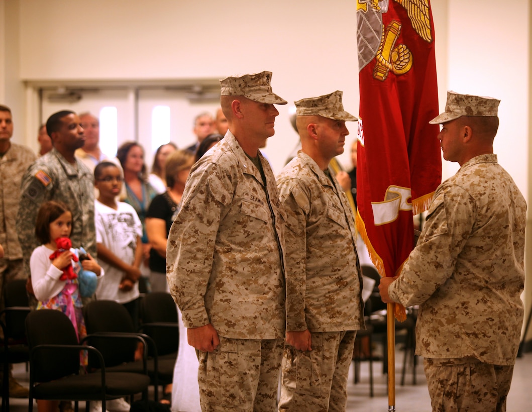 Sgt. Maj. Jon W. Turner, sergeant major of Marine Corps Combat Service Support Schools, presents the MCCSSS guidon to Lt. Col. Timothy B. Seamon, who will then pass it to Lt. Col. Paul F. Bertholf, signifying the official changeover of commanding officers, during the MCCSSS change of command ceremony aboard Camp Johnson July 31. Seamon assumed command of MCCSSS April 13.