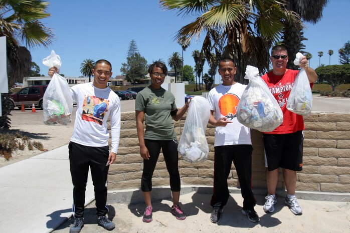 (from left to right) Petty Officer Third Class Loc Nguyen, religious programer, Pfc. Breanna Rivera, administrative clerk, GySgt. Erwin Jumawan, operations chief, and  Lt. Stephen Brown, Chaplain, all with 2nd Recruit Training Battalion volunteered their time to clean Breaker's Beach July 26 aboard Naval Air Station North Island, Coronado, Calif. All service members are encouraged to participate in volunteer work to help boost morale for the unit and it also allows an escape from the work environment.