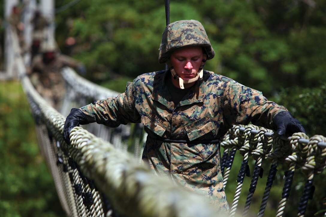 Pfc. Eric R. Weeman crosses a rope bridge at the Jungle Warfare Training Center at Camp Gonsalves July 7. Bridges can be assembled to permit Marines to cross valleys in any location. Weeman is a motor vehicle operator with Marine Wing Support Squadron 172, Marine Aircraft Group 36. 
