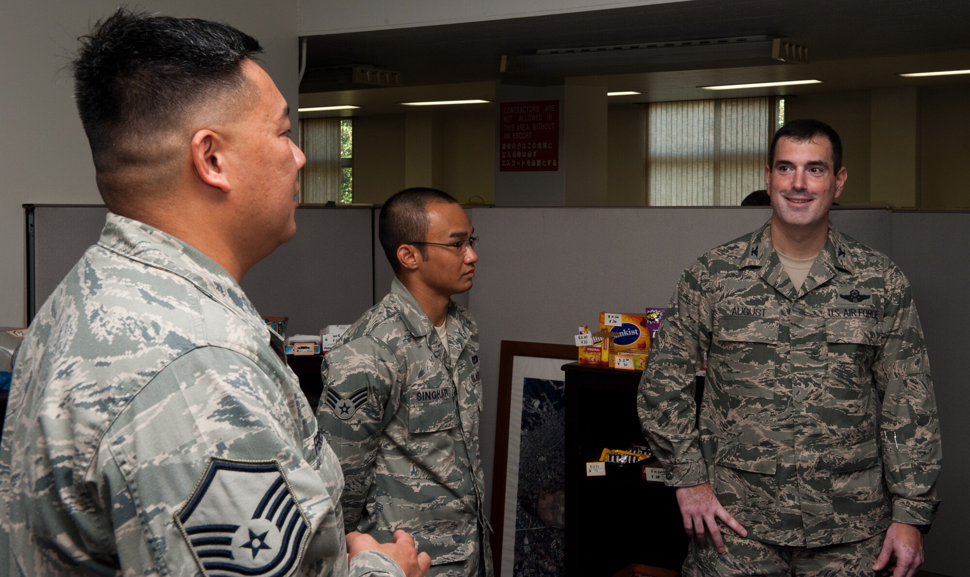 YOKOTA AIR BASE, Japan -- Col. Mark August, right, 374th Airlift Wing commander, speaks with Airmen from the 374th Civil Engineer Squadron at Yokota Air Base, Japan, on July 26, 2012. August gave commander’s coins to members of the squadron’s energy management team after they won the 2012 Federal Energy and Water Management Award. (U.S. Air Force photo by Airman 1st Class John D. Partlow)
