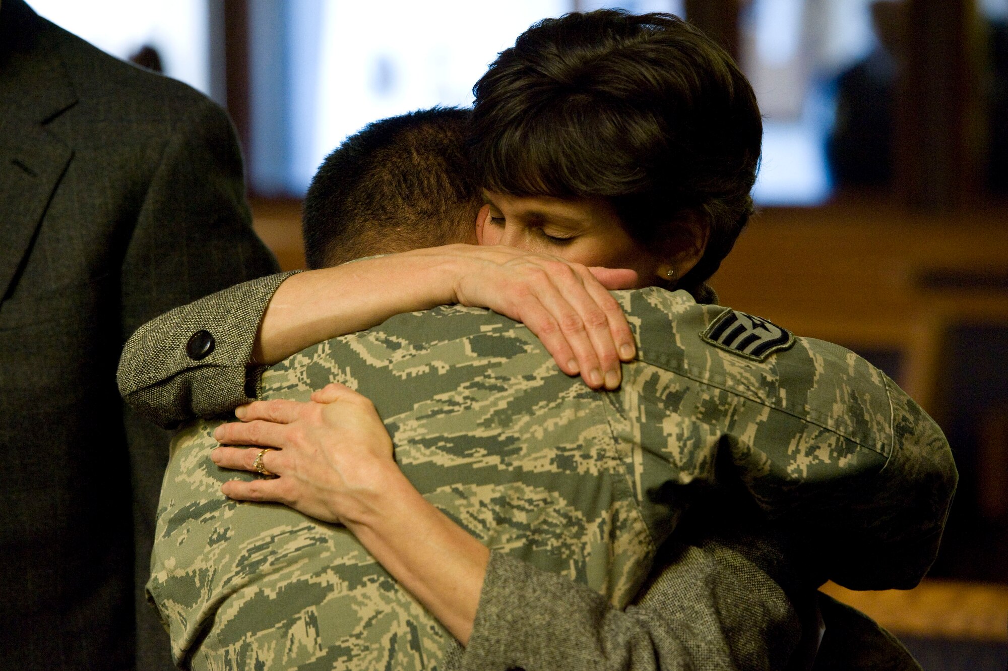A U.S. Air Force Staff Sgt. gives his condolences to Laurie Moore, mother of Senior Airman Derek Moore, 757th Aircraft Maintenance Squadron electrical and environmental systems journeyman, during a memorial service July 27, 2012, at Nellis Air Force Base, Nev. Moore is remembered for his quiet, but generous, laid back personality. (U.S. Air Force photo by Airman 1st Class Christopher Tam)