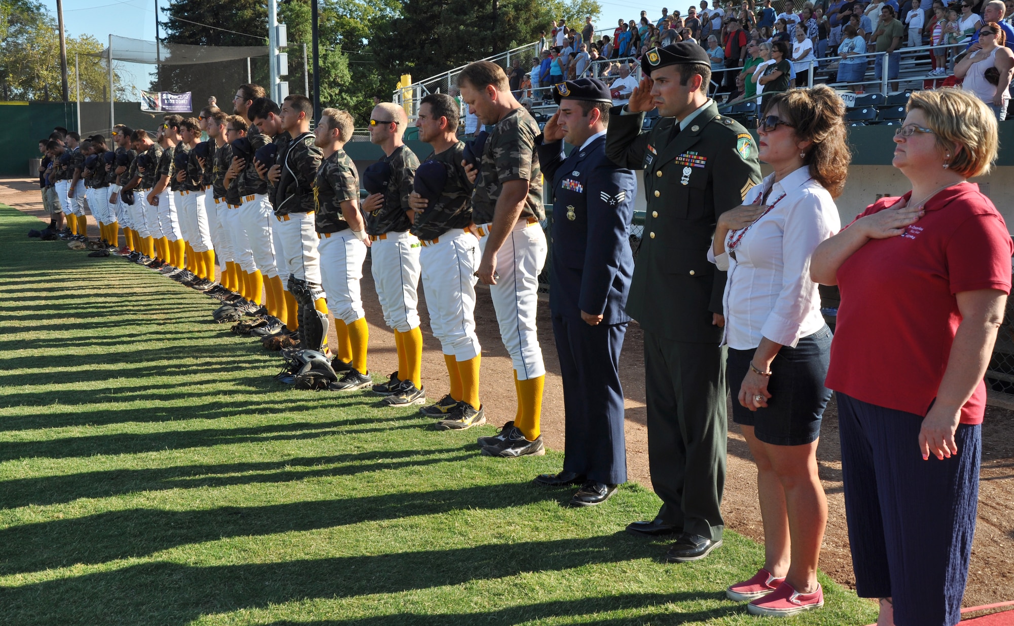 Blue Star Moms, servicemen and Gold Sox Baseball players pay their respects during the national anthem at a military appreciation game at Appeal-Democrat Park, Marysville, Calif., July 29, 2012. BSM is a non-profit organization for mothers and fathers of children serving or have served in the military. (U.S. Air Force photo by Staff Sgt. Robert M. Trujillo)