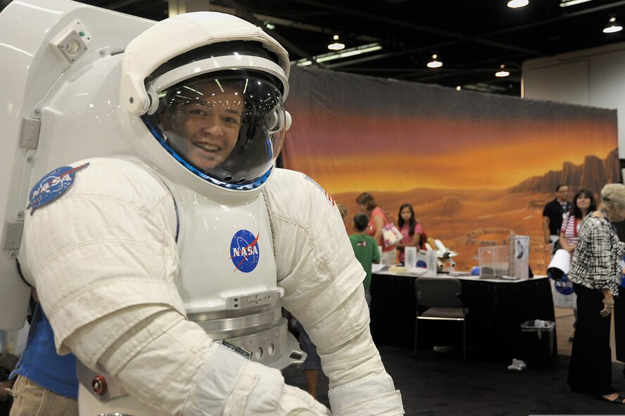 A student tries on a NASA suit. (U.S. Air Force photo)