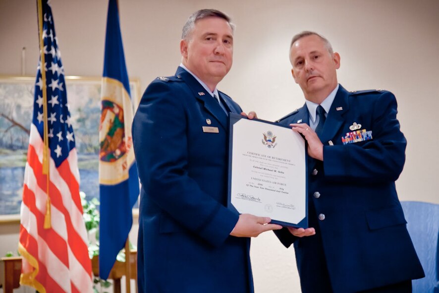 Col. Darrell G. Young, Commander of the 934th Airlift Wing, presents Col. Michael W. Ochs with his certificate of retirement.  Col. Ochs retires after 33 years of military service, his last three as the 934th Mission Support Group commander at Minneapolis-St. Paul Air Reserve Station, Minn.  (Air Force Photo/Shannon McKay)