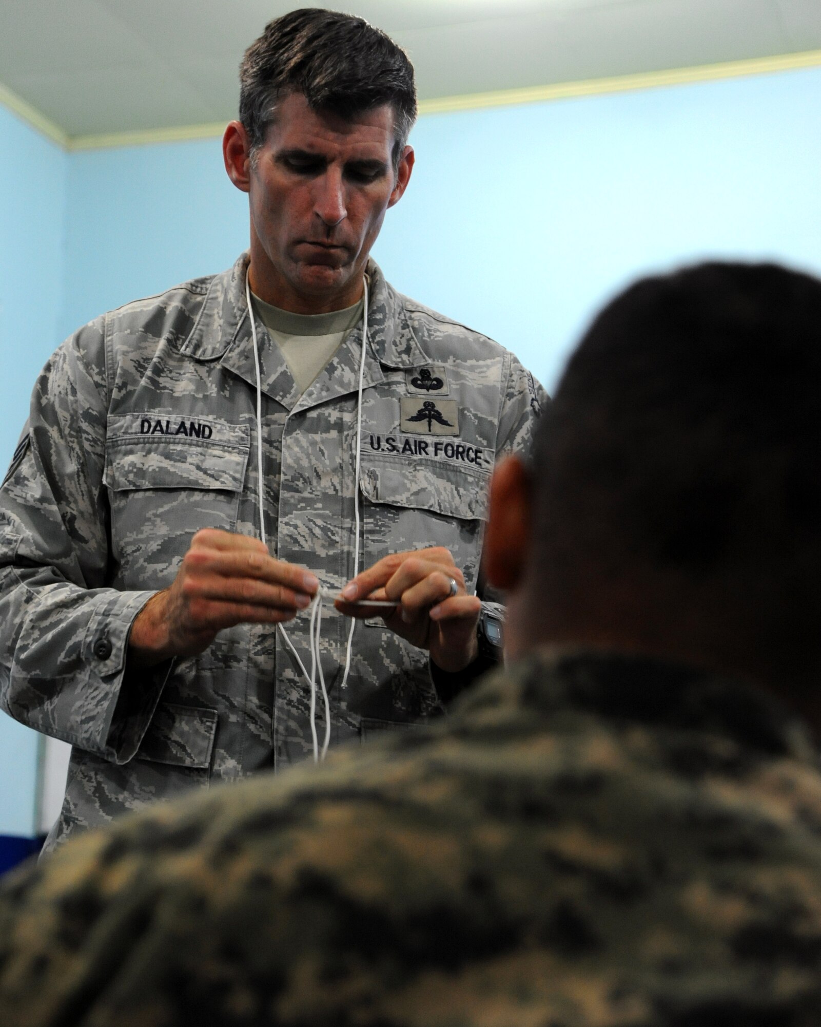 Master Sgt. Troy Daland, a SERE Specialist with the 571st Mobility Support Advisory Squadron, works with Honduran Airmen in Tegucigalpa, Honduras exchanging knowledge about fashioning knots used for survival situations.  Over the next 30 days Daland and his Honduran counterparts will continue trading ideas and experiences while working together to build relationships and partner capacity between the U.S. and Honduran air forces.  (U.S. Air Force photo/Staff Sgt. James Stewart)