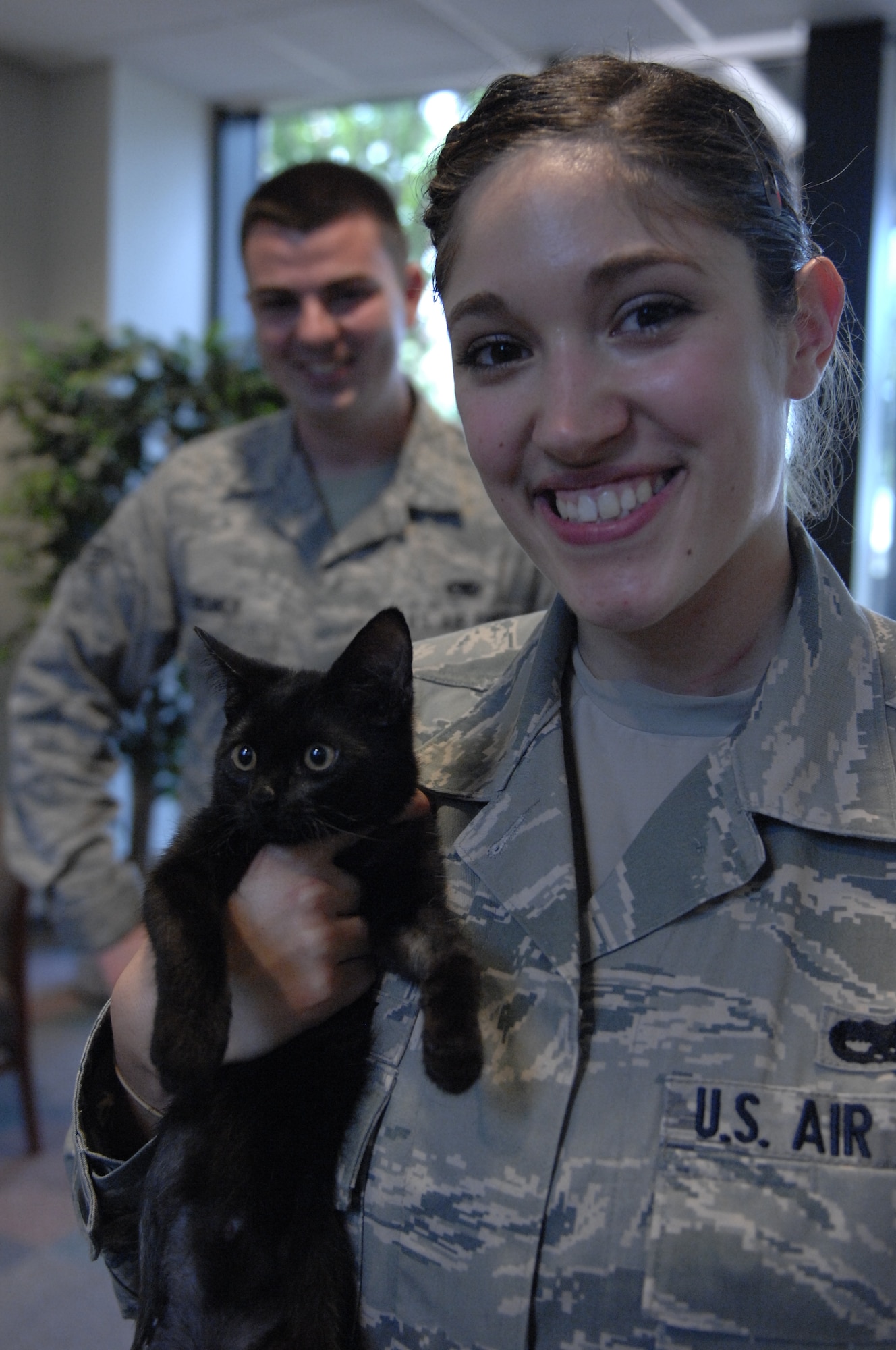 Airman 1st Class Katharina Helmic, 20th Maintenance Operation Squadron aircraft scheduler and a native of Omaha, Neb., poses with her husband Senior Airman James Helmic, 20th Aircraft Maintenance Squadron weapons team chief and a native of Phillipsburg, N.J, and Mila the three legged kitten at Shaw Air Force Base, S.C., July 24, 2012.  The Helmic family rescued Mila after she was discovered fatally injured in a Chevy engine here on June 26, 2012. According to Katharina, the kitten is on the road of recovery and is doing much better. (U.S. Air Force photo by Airman 1st Class Krystal Jeffers/Released)