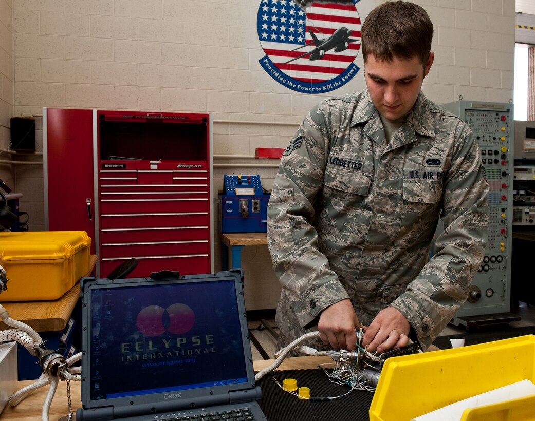 Senior Airman Benjamin Ledbetter, 28th Maintenance Squadron electro-environmental systems technician, hooks a panel to an Eclypse AWTS Tester while troubleshooting a problem at Ellsworth Air Force Base, S.D., July 27, 2012. This machine helps technicians identify problems with switches and buttons B-1 instrument panels to determine they are functioning properly or need to be replaced. (U.S. Air Force photo by Airman 1st Class Alystria Maurer/Released)