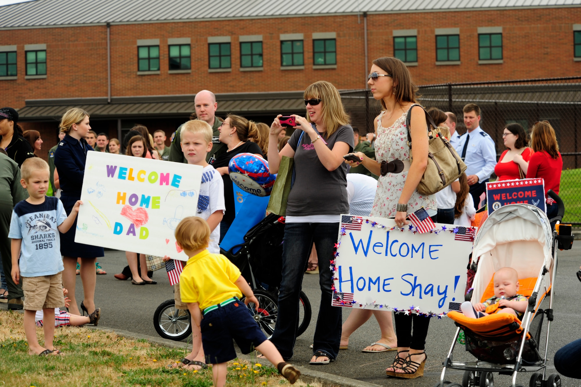 Friends and family members wait in anticipation for the arrival of their loved ones from a deployment, July 30, 2012, at Joint Base Lewis-McChord, Wash. The 8th Airlift Squadron was deployed in support of Operation Enduring Freedom. (U.S. Air Force photo/Adamarie Lewis-Page)